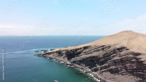 Drone aerial view, blue sea and clear sky blue mountain and boat in Paracas National Park, Peru 4k.