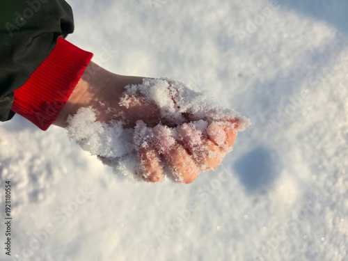 woman’s hand in the snow with snowflakes. Winter background. Close-up, selective focus.