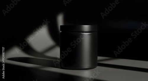 Minimalist black cylindrical container casting a shadow on reflective surface
