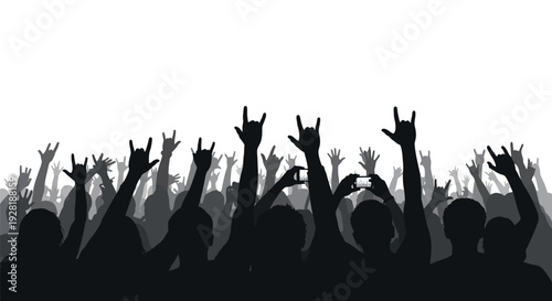 Silhouetted crowd at a concert or music festival with hands raised.