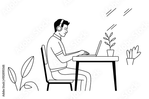 A man wearing headphones works on laptop at a desk in a modern office