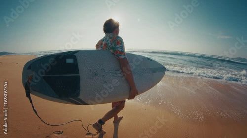 Hippie surfer. Young man in colorful stylish shirt walks on the beach and enters the ocean. Brazilian hippie surfer