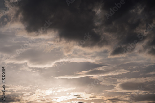 Dramatic sunset sky with dark storm clouds and soft light, moody atmosphere before rainfall