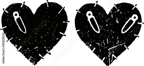 Two rough textured black heart shapes with stitched outlines and safety pins fastened