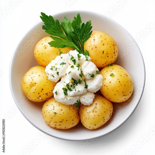 Fresh baby potatoes with smooth yellow skins topped with creamy herb butter and garnished with fresh parsley in a white bowl for healthy side dish