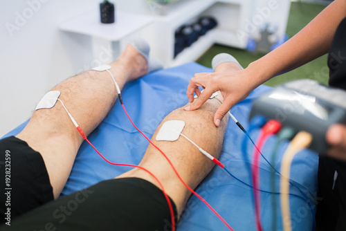Bild auf Leinwand Patient's legs with electrodes and cables during a physiotherapy session
