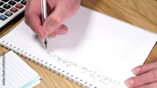 student is solving a difficult equation on blank paper
