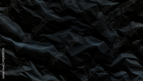 Crumpled black paper texture with deep shadows and dark folds