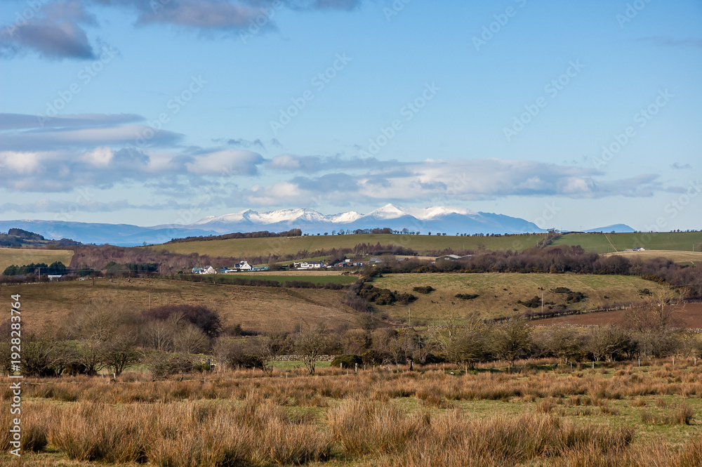 Fototapeta premium Winter view of the snow capped peaks of the Isle of Arran from the Ayrshire countryside