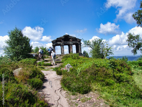 Fényképezés Wanderer erreichen auf dem Weitwanderweg GR5 den Gipfel des Donon auf 1009 Metern in den Hochvogesen mit dem Tempelnachbau aus dem 19