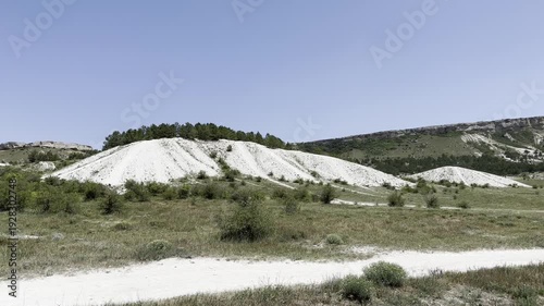 Sand hills and green trees in open field