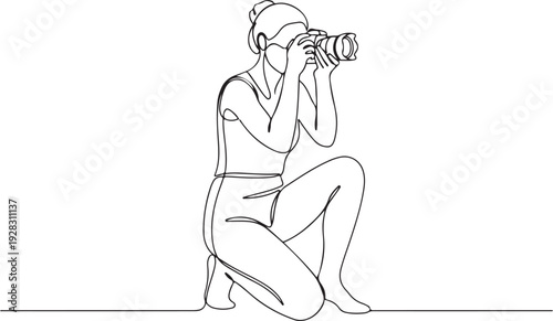 A person crouching down and taking a photograph with a camera