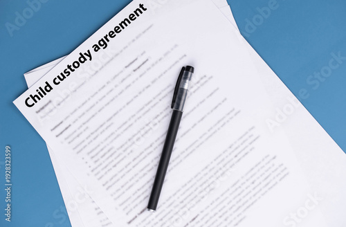 Child custody agreement document on table, legal paperwork for parental rights, divorce settlement, and family law concept.