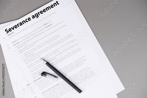 Severance agreement document on office desk, legal contract detailing terms of job termination and severance pay, symbol of closure, protection, and career transition in professional life.