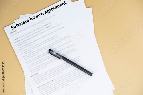 Software license agreement document on office desk, legal contract granting rights to use software under specific terms, symbol of digital compliance, intellectual property, and business technology.