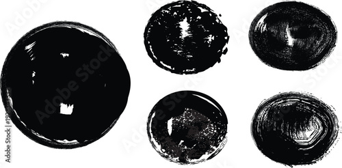 Four black oval objects with reflective surfaces arranged in two rows