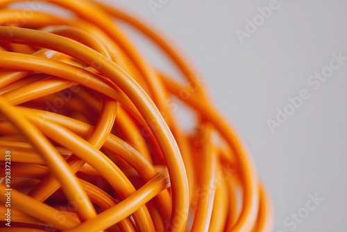 orange electrical cables tangled and intertwined in complex chaotic knot