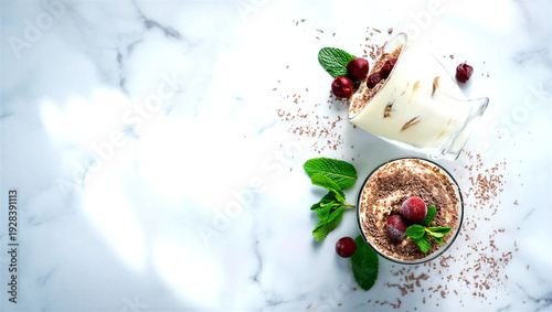 Delicious tiramisu dessert with cherries and mint on marble surface
