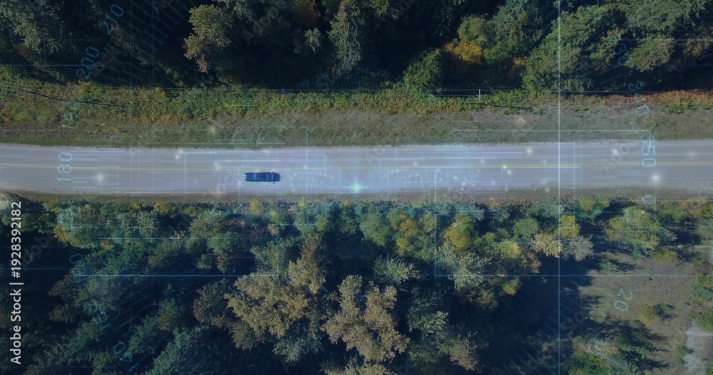Obraz premium Driving dark car traveling along two-lane rural road with grassy verge and telemetry overlay