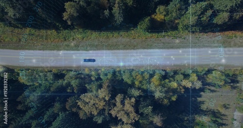 Driving dark car traveling along two-lane rural road with grassy verge and telemetry overlay