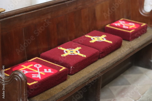 Bild auf Leinwand Red hassocks on a wooden church pew