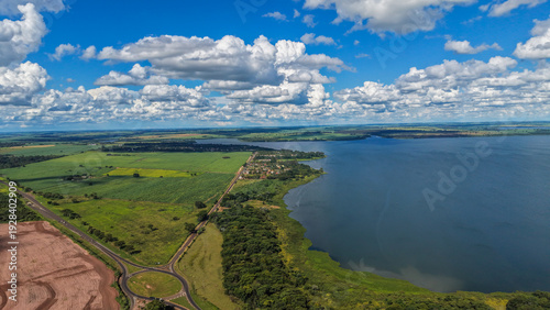 Billede på lærred Aerial view of a serene landscape with a large body of water and green fields un