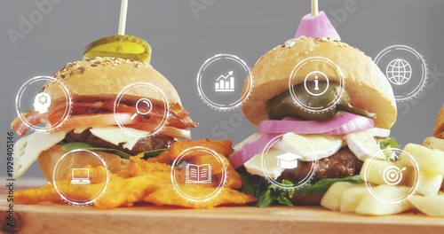 Showing two sesame slider burgers on wood board with fries, crinkle chips, skewers, HUD icons