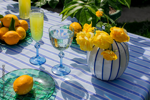 Photography Lemonade glasses and yellow blooms on sunlit table, echoing Summer Solstice zest