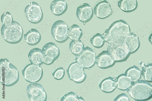 Green cosmetic serum or gel or shampoo on mint background isolated. Beauty product sample swatch