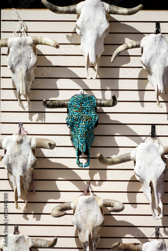 Santa Fe, New Mexico, United States.  Wall full of cow skulls with one covered in turquoise featured