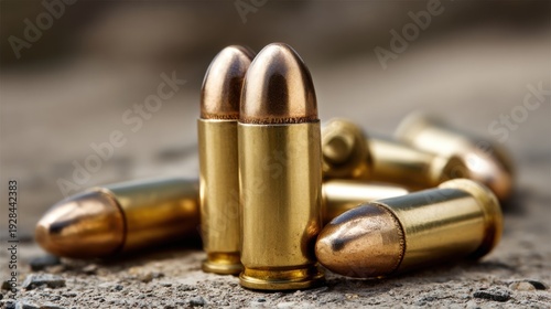 Wallpaper Mural Close-up of gleaming brass bullet cartridges scattered on a textured gravel surface Torontodigital.ca