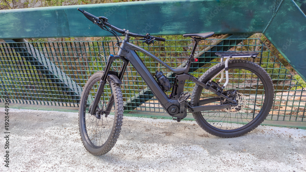 Fototapeta premium Mountain e-bike with luggage rack on a metal bridge