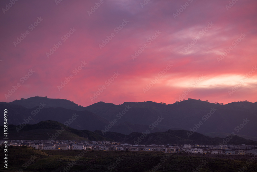 Obraz premium Beautiful pink sunset view of homes on a ridge in Valencia, California, USA.