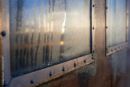 Misty Window Pane with Condensation and Warm Sunlight on a Cold Morning