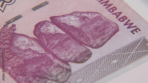Reserve bank of Zimbabwe in Southern South Africa with inflation and inflated economy of printed cash dollar bills in thoughts, billions, and millions of dollars bill on paper surface in old Rhodesia