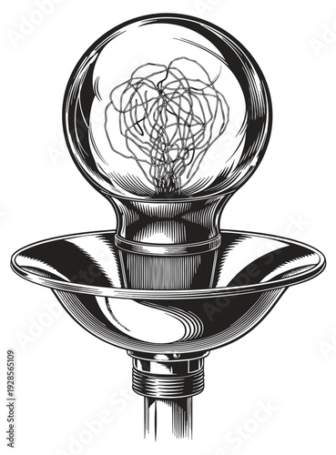 A tangled wire inside a clear glass light bulb on a metal lamp holder viewed from a slight angle