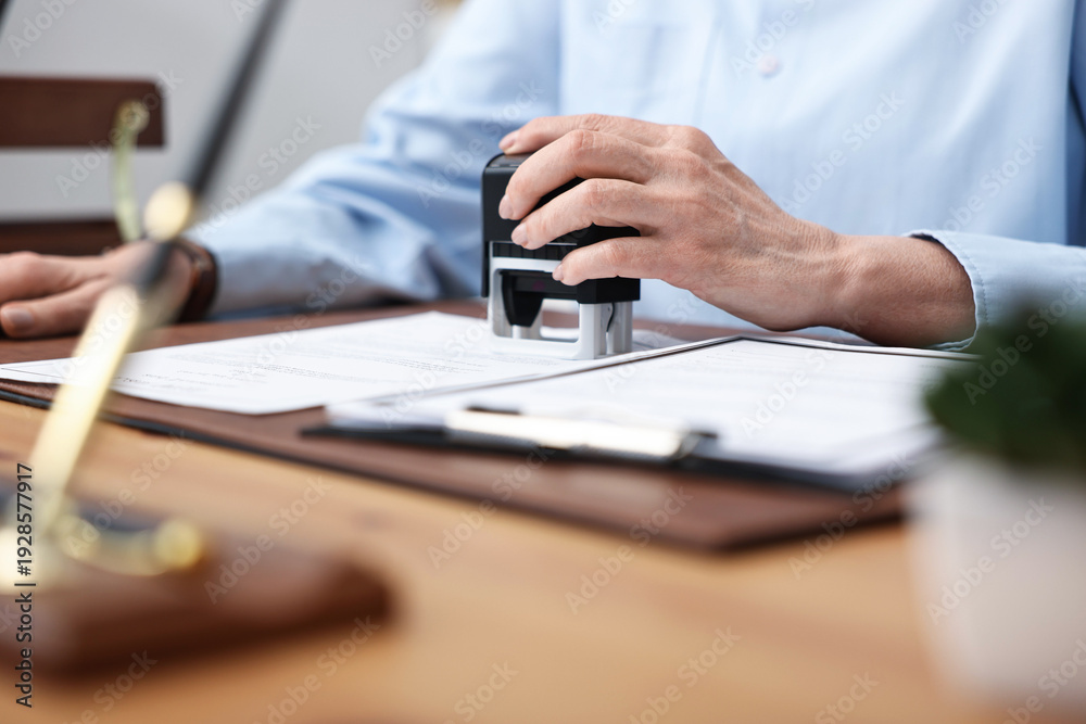 Fototapeta premium Notary stamping document at desk in office, closeup