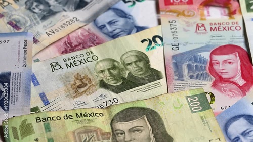 Money concept, mexican banknotes of various denominations rotating on a flat table