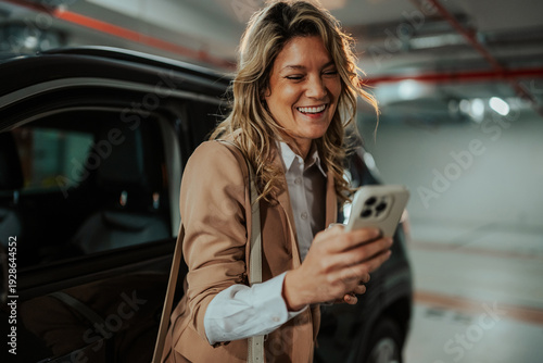 Wallpaper Mural Happy woman smiling and using smartphone in a parking garage, enjoying mobile technology app Torontodigital.ca