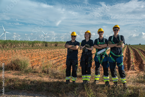 Foto Industrial HSE safety supervisors and engineering workforce wearing full fall protection PPE posing at wind farm site
