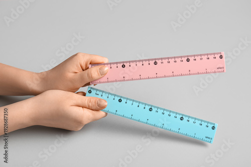 Female hands with rulers on...