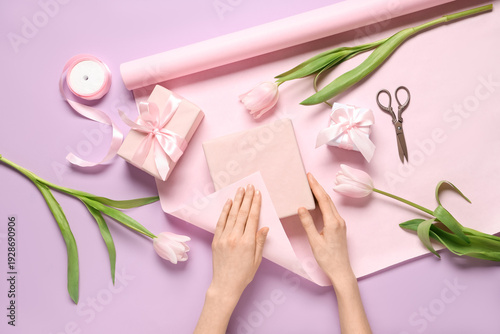 Young woman wrapping gift b...