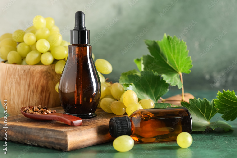 Obraz premium Bottles of cosmetic grape seed oil on green background