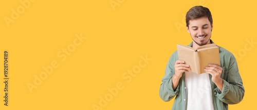 Young man reading book on y...