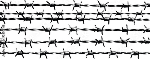 Multiple rows of barbed wire stretched horizontally across the frame, viewed from a straight-on perspective