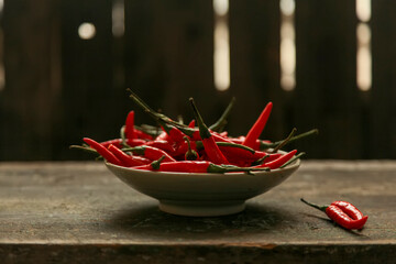 Papier peint photo Piments forts Bol de piments sur table bois  © Gloream