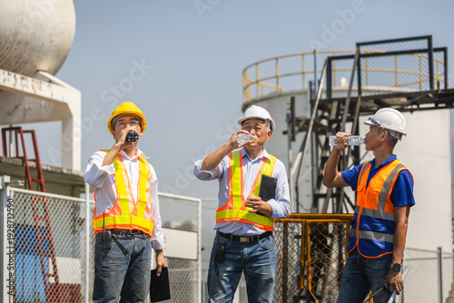 Cuadro en lienzo Group of diverse engineers drinking bottled water to stay hydrated at industrial