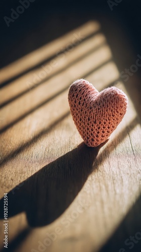 Pink crocheted heart on a wooden surface.