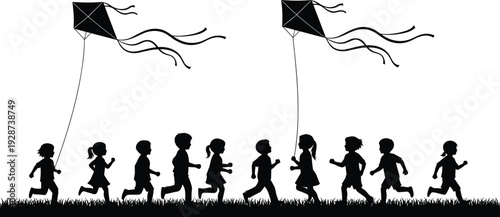 Silhouette of a group of happy children running on grass field and flying kites in the sky during summer vacation