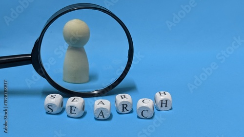 Φωτογραφία Magnifying glass focusing on a small wooden figure among letters